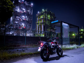 Bicycles on street against illuminated buildings in city at night