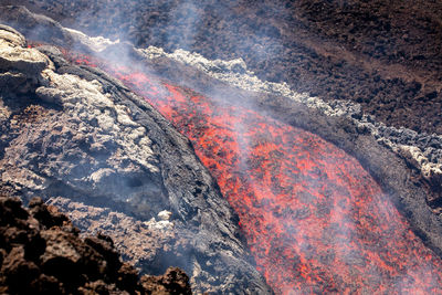 Etna- lava fall detail on volcano  in sicily with smoke and acid vapor
