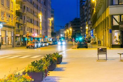 Illuminated city street against clear sky at night