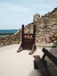 Hooded chairs on beach against sky