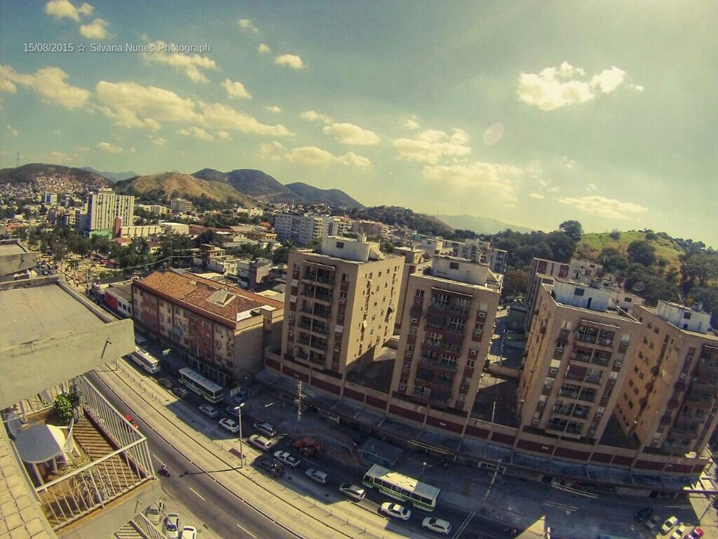 building exterior, architecture, built structure, city, cityscape, sky, high angle view, car, residential building, transportation, residential district, crowded, city life, cloud - sky, residential structure, street, road, land vehicle, mode of transport, cloud