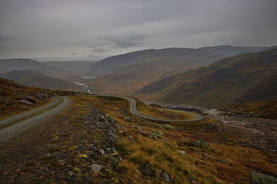 Scenic view of road amidst mountains against sky