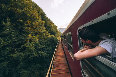 Boy on railroad track against sky