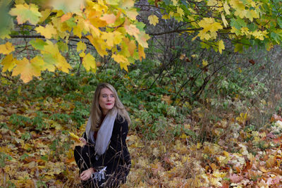 Portrait of young woman in autumn leaves