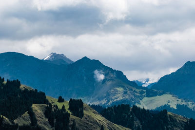 Scenic view of mountains against cloudy sky