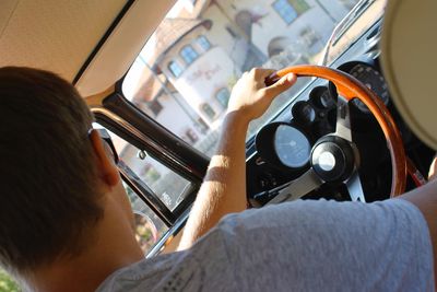 Rear view of man driving vintage car on sunny day