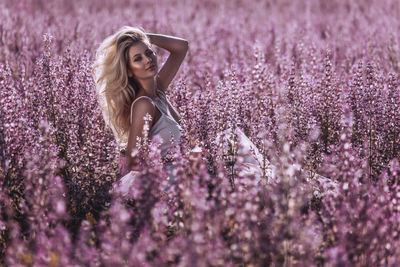 Full length of woman standing on purple flowering plants