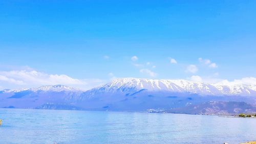 Scenic view of snowcapped mountains against blue sky