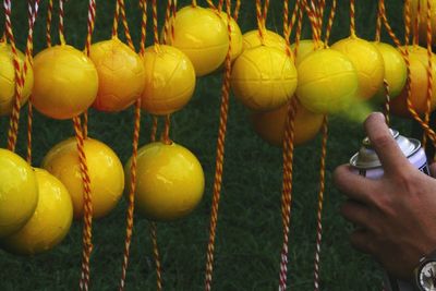 Cropped hand spraying paint on balls