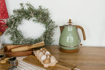 Turquoise electric kettle, eggs, christmas wreath, wooden rolling pins in the kitchen