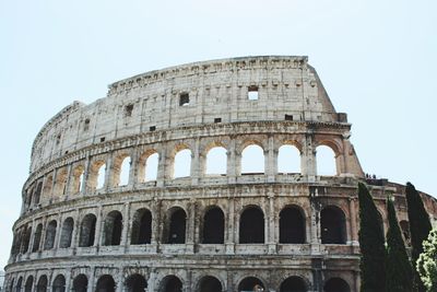 Low angle view of coliseum against sky in city