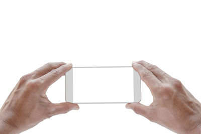 Low angle view of hand holding smart phone against white background