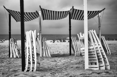 Chairs on beach against sky