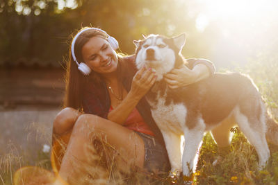 Portrait of woman with dog on field