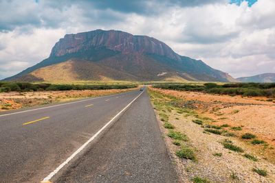 An empty highway against the background of mount ololokwe in marsabit county, kenya