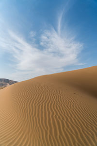 View of badain jaran desert against cloudy sky