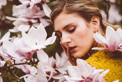 Young woman amidst pink flowers during springtime