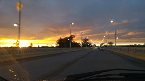 Road passing through illuminated city at night