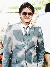 Portrait of young man wearing sunglasses standing outdoors