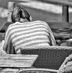 Rear view of woman sitting outdoors