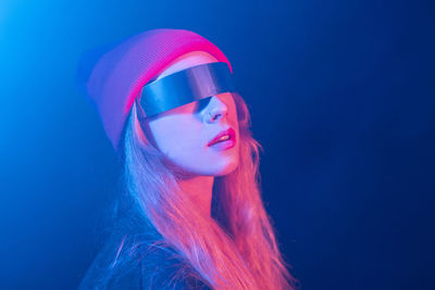 Portrait of a beautiful young woman against blue background