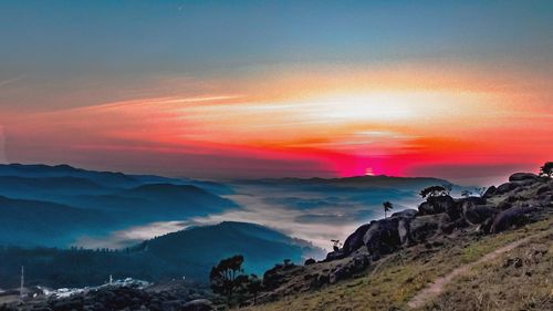 Scenic view of sea and mountains against sky during sunset