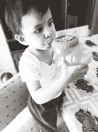 Cute girl sitting on table at home