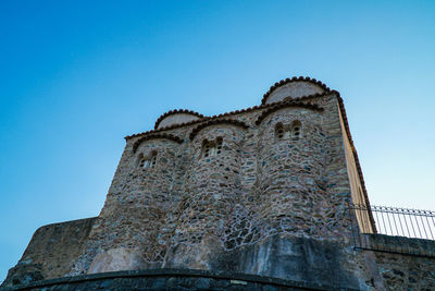 Low angle view of old building against clear blue sky