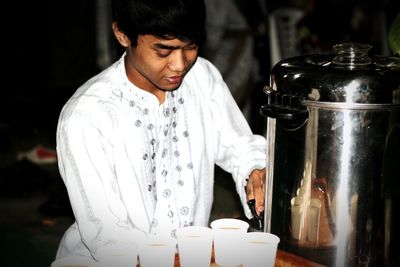 Young man serving coffee at cafe