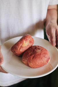 Cropped hand of person holding food in plate