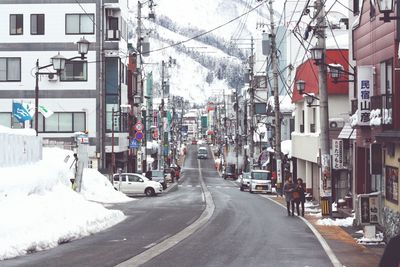 Street amidst buildings in city during winter