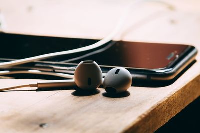 Close-up of headphones and smart phone on table