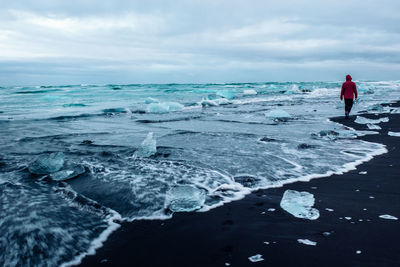 Iceland coast with a waves and walking man. jokulsarlon.