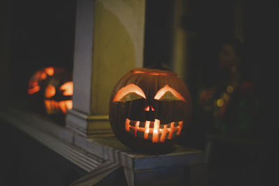 Close-up of illuminated jack o lanterns on retaining wall