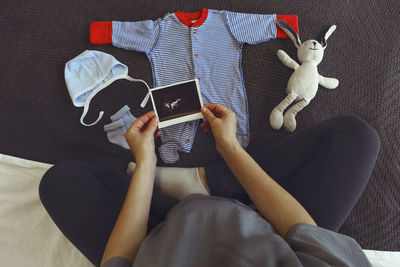 Low section of woman using mobile phone while sitting on sofa at home