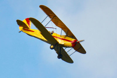 Low angle view of airplane against clear blue sky