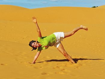 Full length portrait of happy woman enjoying in desert at mui ne bay