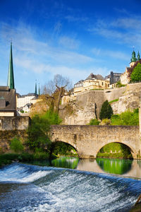 Arch bridge over river against buildings