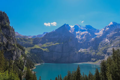 Scenic view of lake and mountains against blue sky