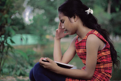 Side view of woman using smart phone outdoors