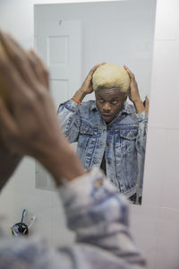 A young man getting ready in the mirror