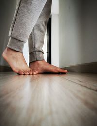 Low section of woman standing on hardwood floor