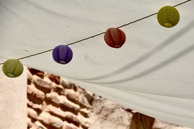 Low angle view of lanterns hanging on wall