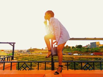 Young woman against clear sky