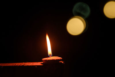 Close-up of lit candle against black background