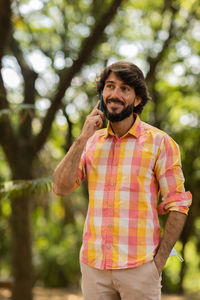 Young man at park on a beautiful sunny day with mobile phone.  working  leisure. green and nature 