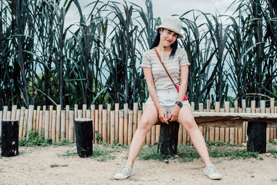 Full length portrait of woman against plants