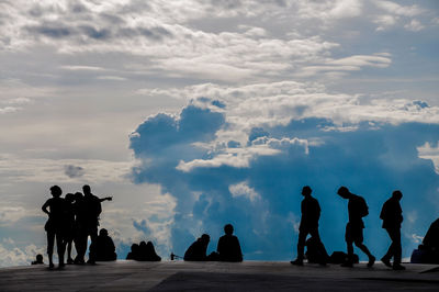 Silhouette people against sky