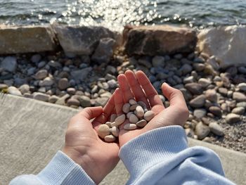 Pebbles picked up from the edge of the lake.  a pebble in a girl's hand