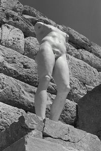 Low section of man sitting on rock